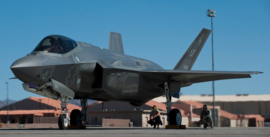 Senior Airman Patrick Murphy, 61st Aircraft Maintenance Unit Staff F-35 dedicated crew chief, and Staff Sgt. Jeremy Miller, 61st AMU integrated avionics craftsman, monitor an F-35 prior to take off April 15, 2015 at Nellis Air Force Base, Nevada. (U.S. Air Force photo by Senior Airman Thomas Spangler)