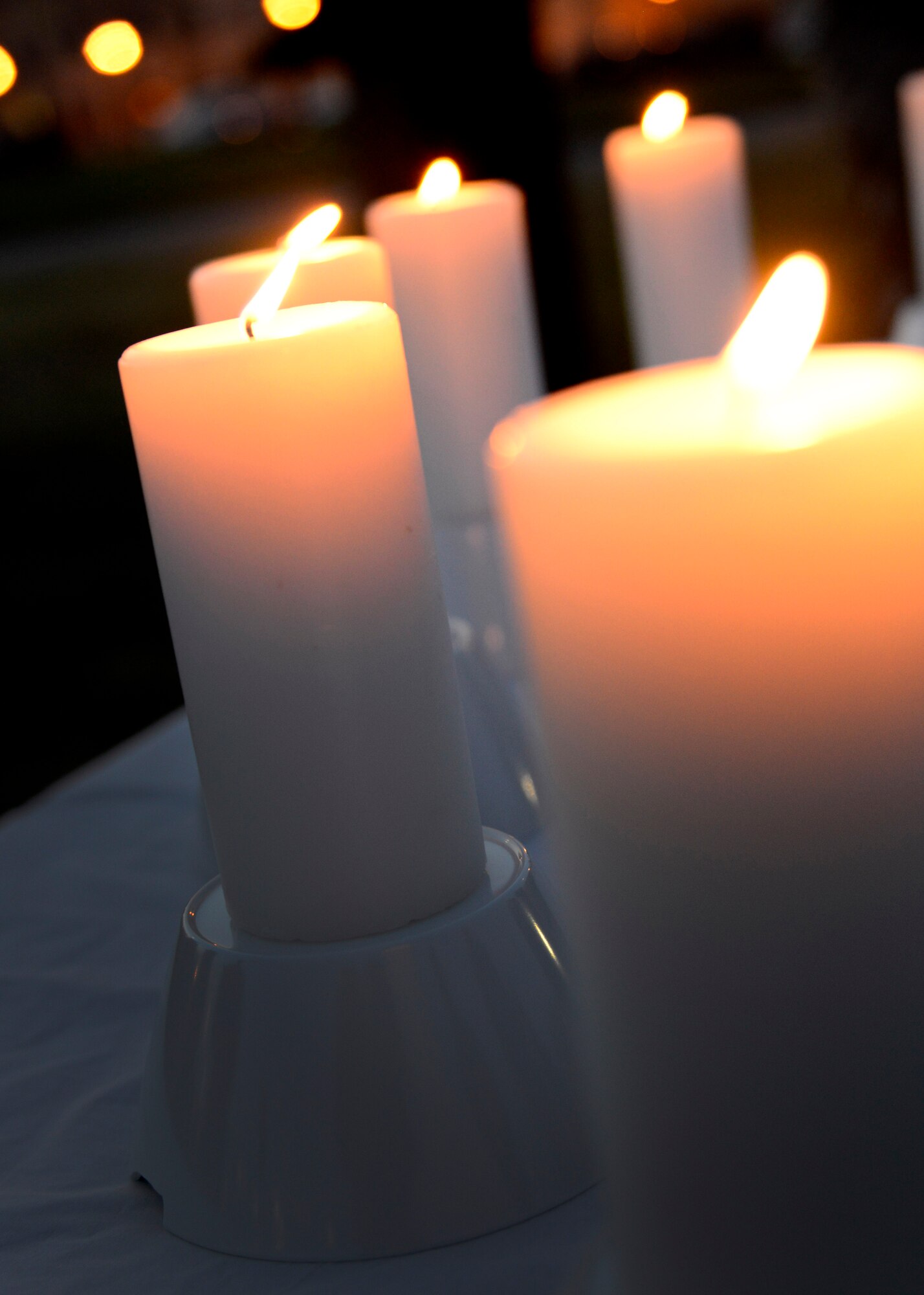 Seven candles burn during the Holocaust Days of Remembrance candlelight vigil, April 15, 2015, at Aviano Air Base, Italy. Six of the candles represented the approximately 6 million Jewish people who died during the Holocaust. The seventh candle honors people of other faiths and ethnicities also murdered during the Holocaust. (U.S. Air Force photo by Senior Airman Areca T. Wilson/Released)