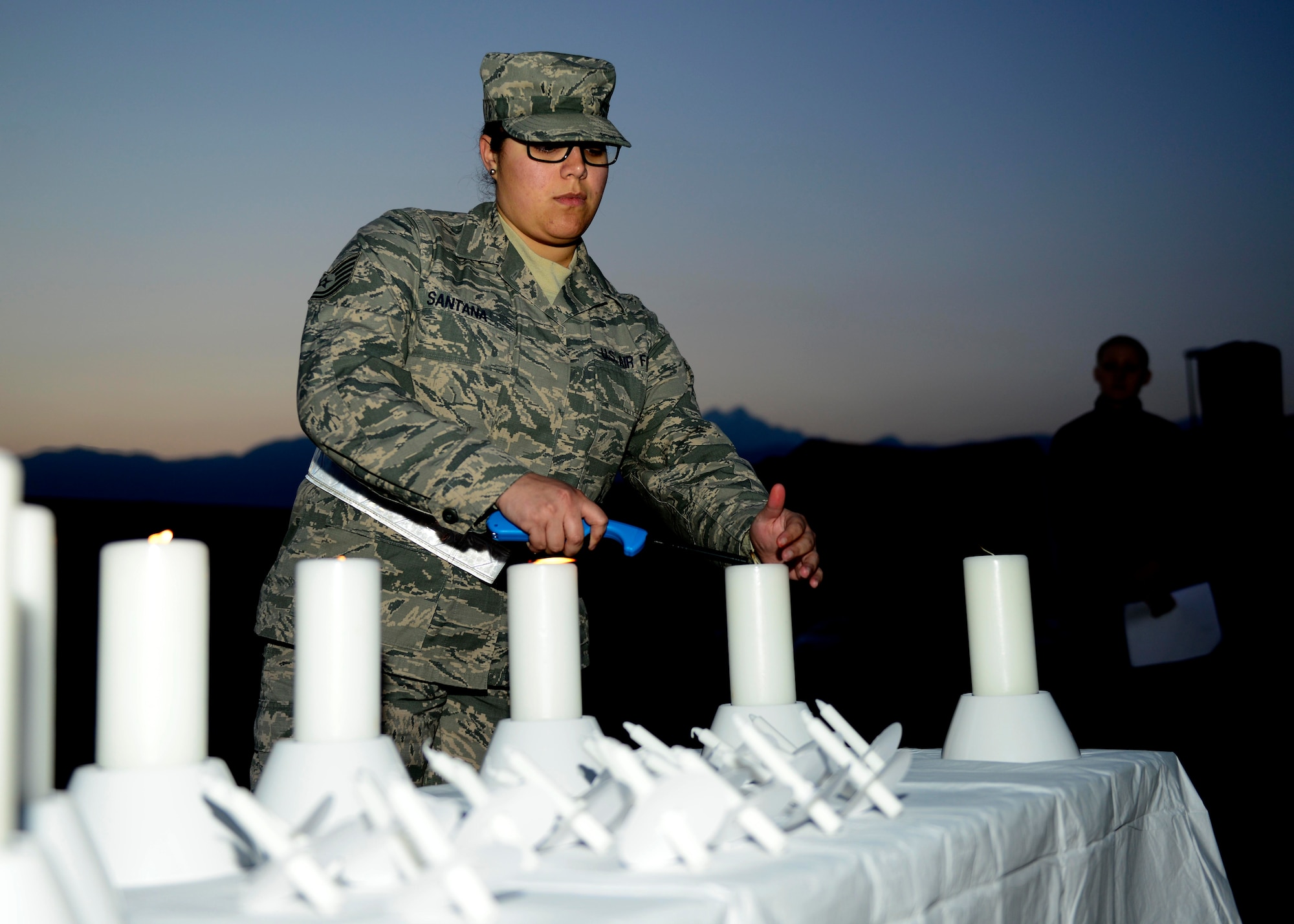 U.S. Air Force Tech. Sgt. Josephine Santana, 31st Logistics Readiness Squadron customer service noncommissioned officer in charge, lights candles during the Holocaust Days of Remembrance candlelight vigil, April 15, 2015, at Aviano Air Base, Italy. From 1941 to 1945, under orders from Adolf Hitler, the Nazi regime targeted, imprisoned and murdered any political, ethnic or religious group viewed as an opposition to the Third Reich. (U.S. Air Force photo by Senior Airman Areca T. Wilson/Released)