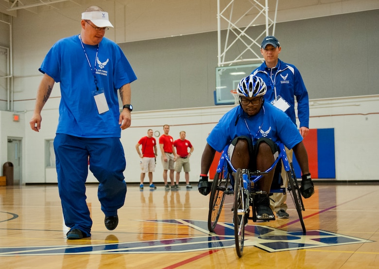 Tech. Sgt. Ryan Delaney, an Air Force Wounded Warrior mentor, watches Tremayne Maxwell, an Air Force Wounded Warrior athlete, perfect his wheelchair basketball rolling skills during the first day of an introductory adaptive sports and rehabilitation camp at Eglin Air Force Base, Fla., April 13.  Delaney, a flight chief with the 412th Security Forces Squadron at Edwards AFB, Calif., helped prepare approximately 45 participants in the week-long camp and training events.  (U.S. Air Force photo/Samuel King Jr.)