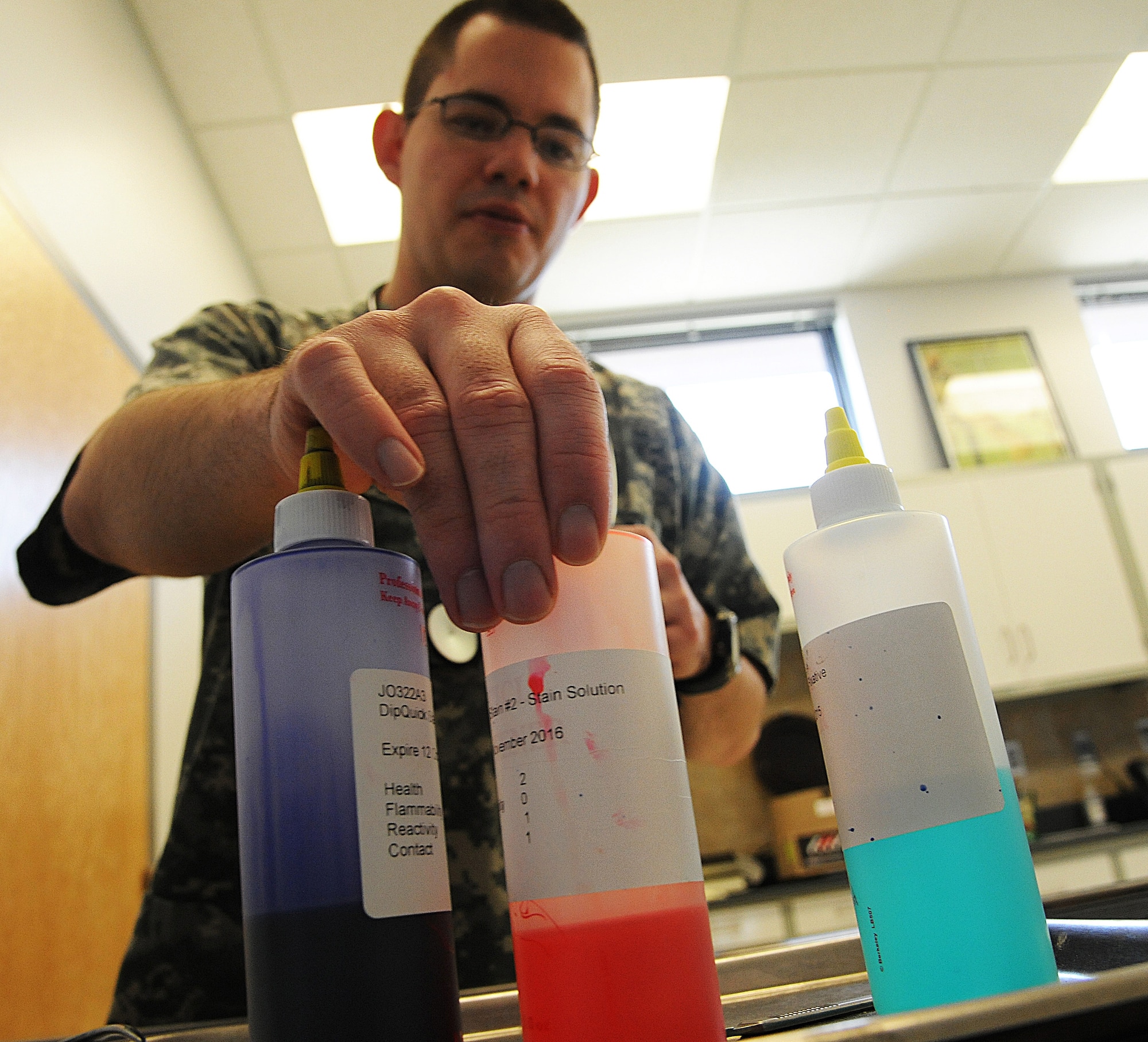 U.S. Army Sergeant Travis Webster, Vet Clinic veterinary technician, prepares to stain a microscope slide at Whiteman Air Force Base, Mo., April 1, 2015. The slides are stained to allow the vets to view bacteria through the microscope. (U.S. Air Force photo by Senior Airman Keenan Berry/Released)