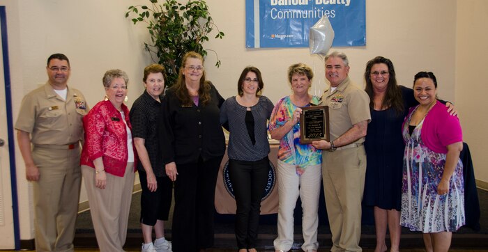 CAPT Timothy Sparks, Joint Base Charleston deputy commander, presents a volunteer appreciation award to the Navy Wives Club of America MenRiv Park #240, April 16, 2015 at Joint Base Charleston – Weapons Station, S.C. National Volunteer Week (April 12-18, 2015) is a program established by the Points of Light. Points of Light was founded in 1990 by President George H.W. Bush as an independent, nonpartisan, nonprofit organization to encourage and empower the spirit of service. (U.S. Air Force photo/Staff Sgt. AJ Hyatt)

