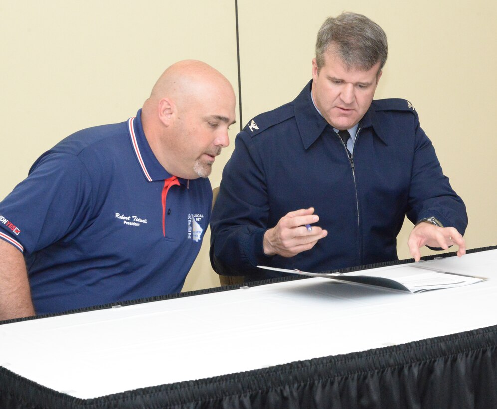 Left, Robbie Tidwell, American Federation of Government Employees, Local 987 president and Col. Chris Hill, Installation commander, discuss the local supplement agreement prior to signing. (U.S. Air Force photo by Ray Crayton)