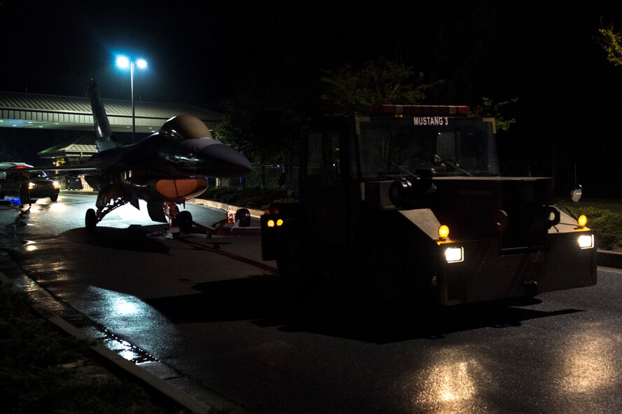 The 23d Equipment Maintenance Squadron transports an F-16 Fighting Falcon static display through the south gate April 13, 2015, at Moody Air Force Base, Ga. The 23d EMS worked overnight to prevent traffic disruptions while transporting the retired aircraft to their fabrication flight paint facility. (U.S. Air Force photo by Airman 1st Class Dillian Bamman/Released)