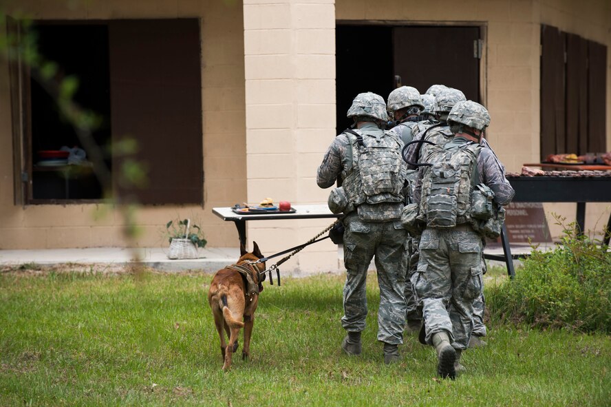 An 820th Base Defense Group fire team prepares to secure a hostile building during a military operations in urban terrain demonstration for the 2015 Safeside Reunion April 11, 2015, at Moody Air Force Base, Ga. Veterans, current base defenders and their familes were invited to the reunion, which Moody hosts biennially. (U.S. Air Force photo by Airman 1st Class Dillian Bamman/Released)