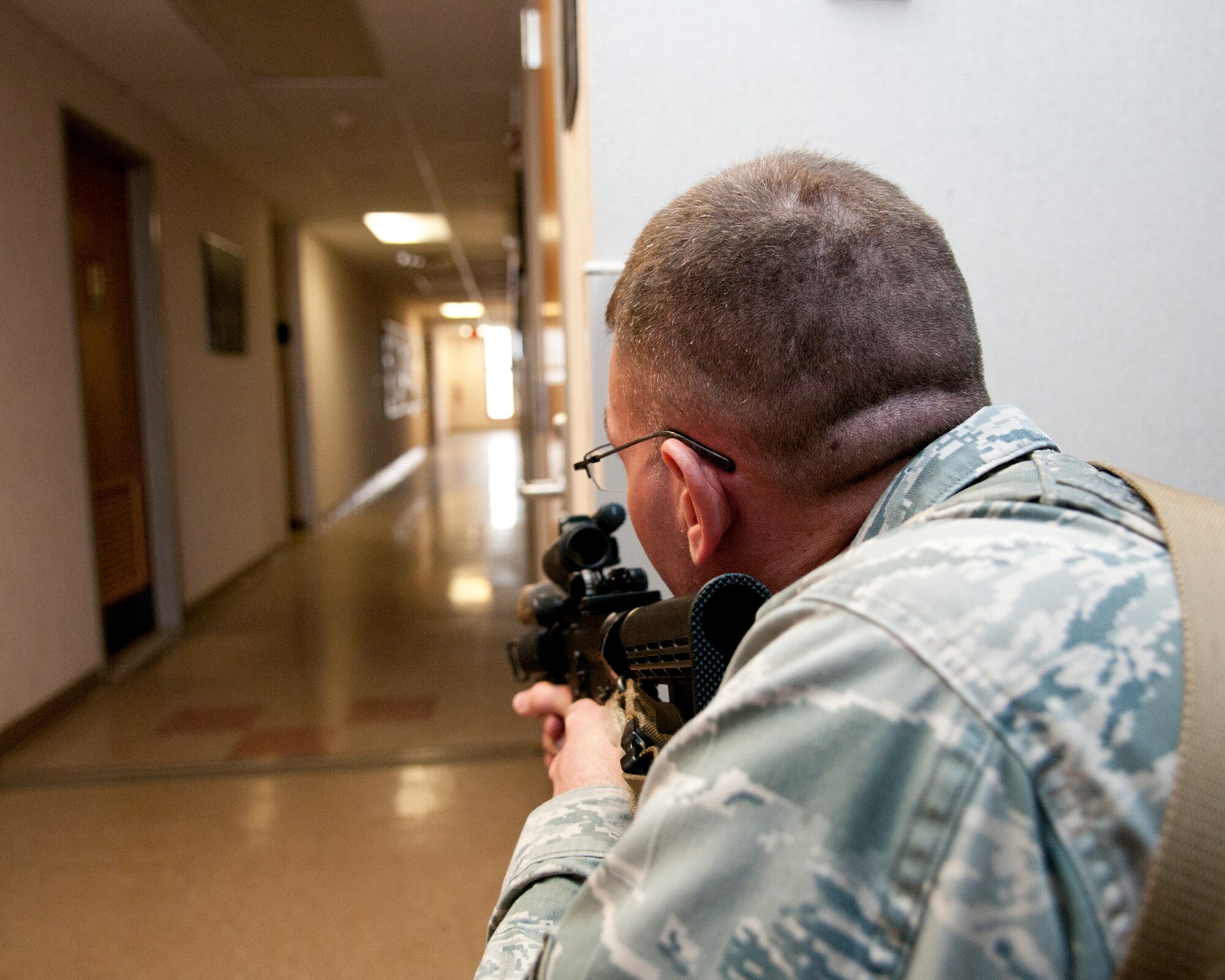 U.S. Air Force Tech. Sgt. Gregory Oberfield, with the 121st Security Forces Squadron, provides cover in response to a simulated active shooter training exercise April 15, 2015 at Rickenbacker Air National Guard Base, Ohio. The training exercise was held to test the reactions of military members and the response time of security forces personnel. (U.S. Air National Guard photo by Tech. Sgt. Zachary Wintgens/Released)