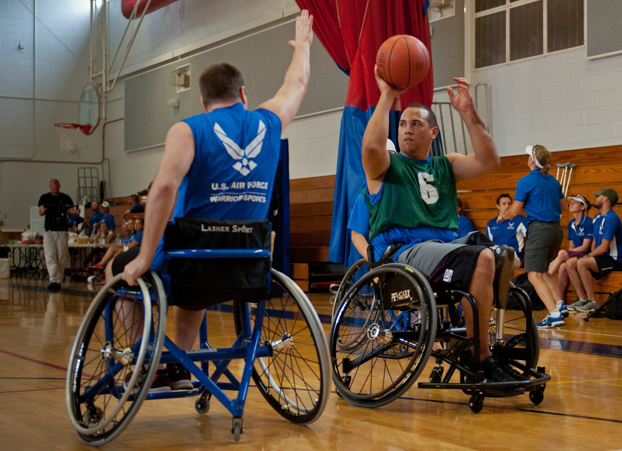 Brian Williams, an Air Force Wounded Warrior athlete, looks for a teammate to pass to at a wheelchair basketball scrimmage game during the fourth day of an introductory adaptive sports and rehabilitation camp at Eglin Air Force Base, Fla., April 16. The DOD’s military adaptive sports program enhances warrior recovery by engaging wounded, ill and injured service members in ongoing, daily adaptive activities, based on their interest and ability. (U.S. Air Force photo/Samuel King Jr.)