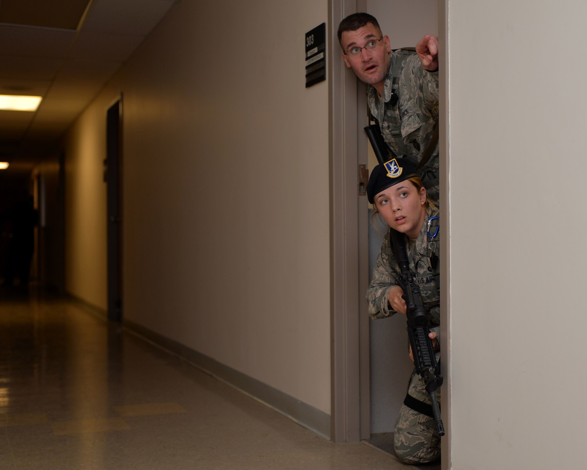 U.S. Air Force Tech. Sgt. Gregory Oberfield and Airman 1st Class Celina Huffman, with the 121st Security Forces Squadron, use cover to secure a building during an active shooter training exercise April 15, 2015 at Rickenbacker Air National Guard Base, Ohio. The training exercise was held to test the reaction of military members and the response time of security forces. (U.S. Air National Guard photo by Airman Ashley Williams/Released)