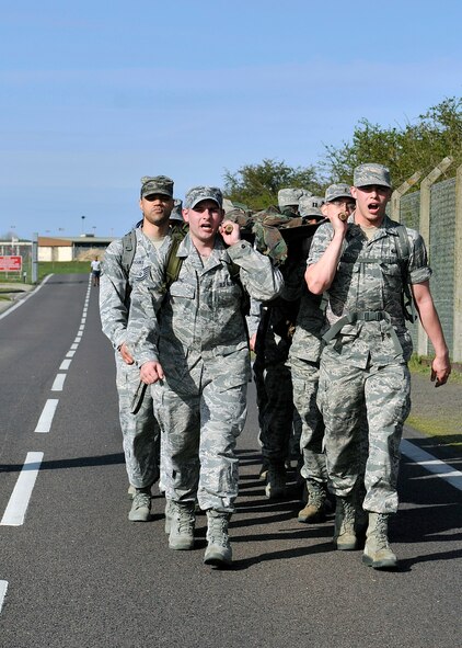 Airmen from the 100th Force Support Squadron march toward the finish line carrying a simulated “injured” warrior during a Holocaust Remembrance ruck march and monthly wing 5K run April 16, 2015, on RAF Mildenhall, England. The ruck was held in honor of Holocaust Remembrance Week, and Team Mildenhall came together to show their support. (U.S. Air Force photo by Airman 1st Class Kyla Gifford/Released)