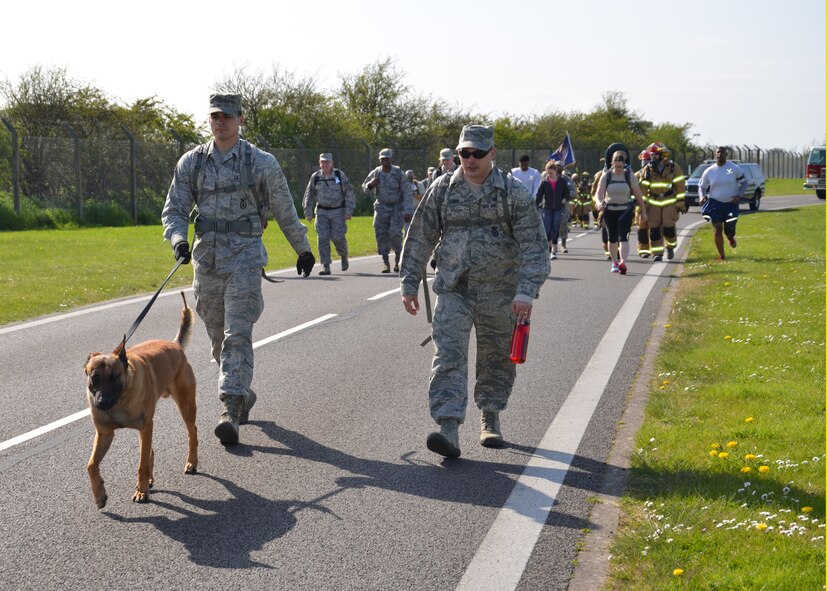 Team Mildenhall members, including Military Working Dog Oorion, participate in a Holocaust Remembrance ruck march and monthly wing 5K run April 16, 2015, on RAF Mildenhall, England. In honor of Holocaust Remembrance Week Team Mildenhall squadrons formed teams for the ruck march to raise morale and show support. (U.S. Air Force photo by Karen Abeyasekere /Released) 