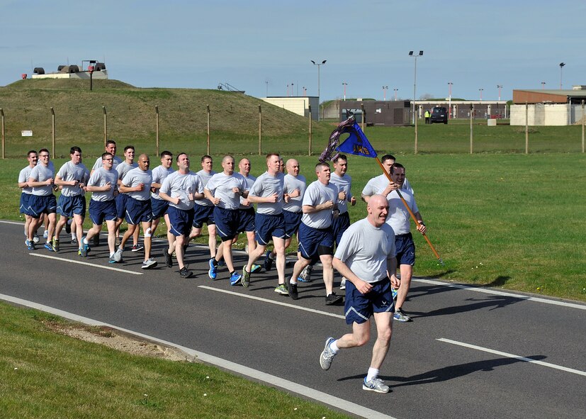 Airmen from the 100th Aircraft Maintenance Squadron run in formation during a Holocaust Remembrance ruck march and monthly wing 5K run April 16, 2015, on RAF Mildenhall, England. In honor of Holocaust Remembrance Week Team Mildenhall squadrons formed teams for the ruck march to raise morale and show support. (U.S. Air Force photo by Airman 1st Class Kyla Gifford/Released) 