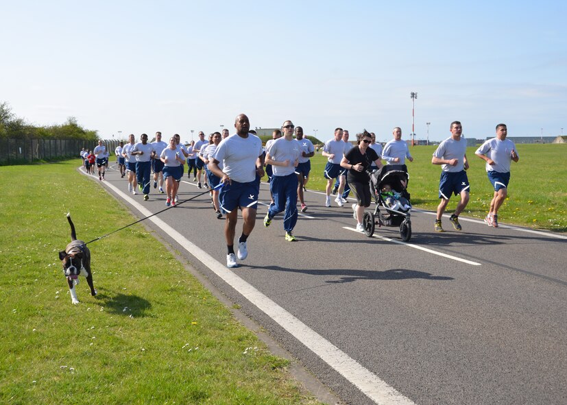 Team Mildenhall Airmen, pets and family members run during a Holocaust Remembrance ruck march and monthly wing 5K April 16, 2015, on RAF Mildenhall, England. The 5K run this month was dedicated to honoring those who suffered and lost their lives during the Holocaust. (U.S. Air Force photo by Karen Abeyasekere/Released)