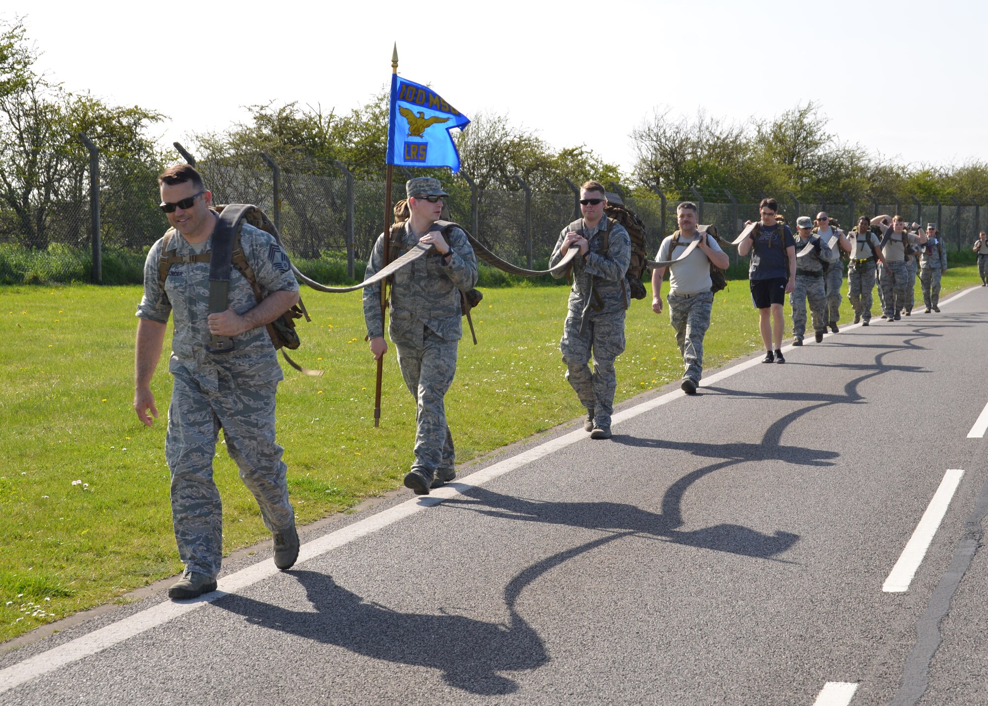 Airmen from the 100th Logistics Readiness Squadron carry a hose as a team during a Holocaust Remembrance ruck march and monthly wing 5K run April 16, 2015, on RAF Mildenhall, England. In honor of Holocaust Remembrance Week Team Mildenhall squadrons formed teams for the ruck march to raise morale and show support. (U.S. Air Force photo by Karen Abeyasekere/Released)