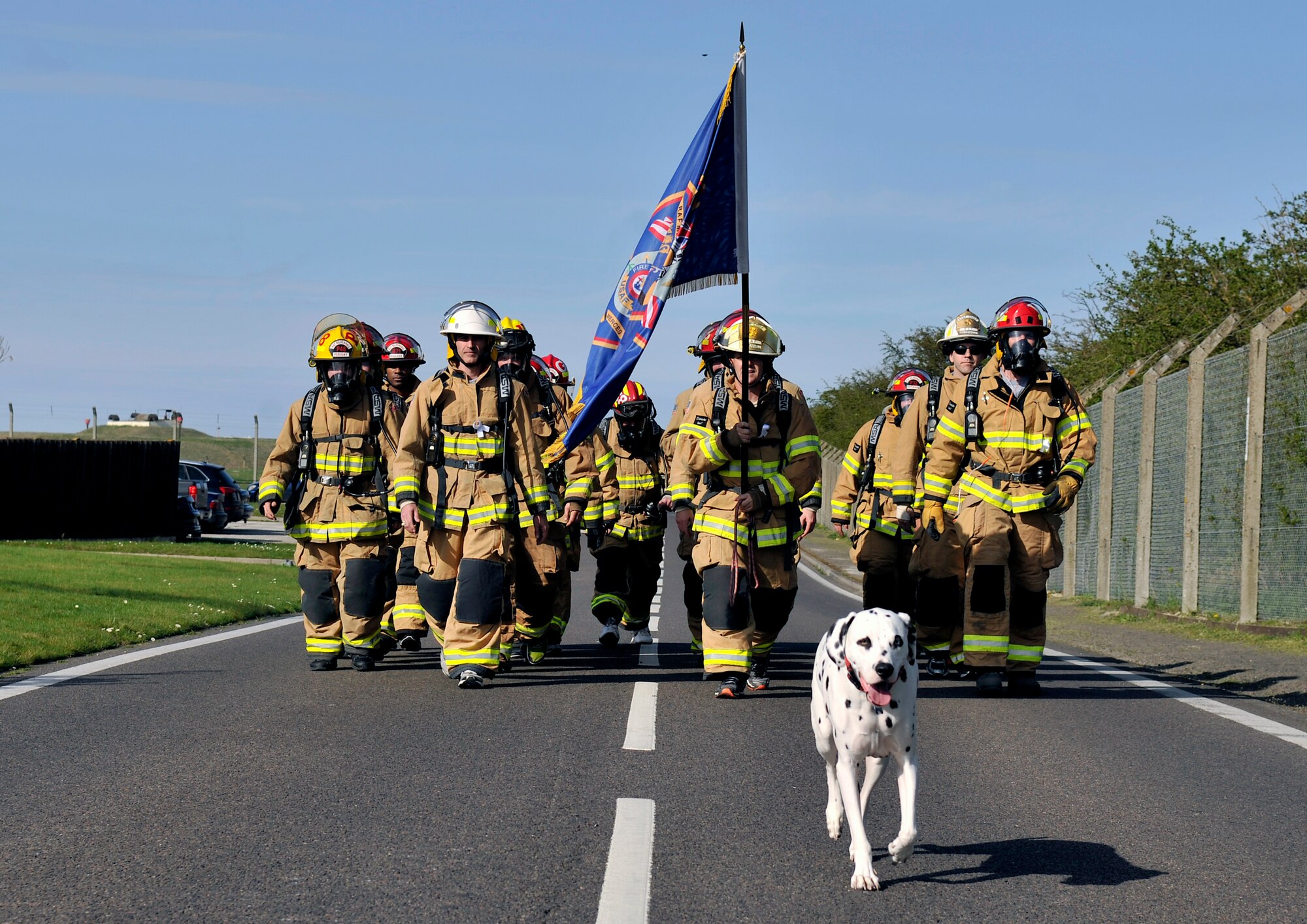 Firefighters from the 100th Civil Engineer Squadron Fire Department march toward the finish line during a Holocaust Remembrance ruck march and monthly wing 5K run April 16, 2015, on RAF Mildenhall, England. The ruck was held in honor of Holocaust Remembrance Week, and Team Mildenhall came together to show their support. (U.S. Air Force photo by Airman 1st Class Kyla Gifford/Released)