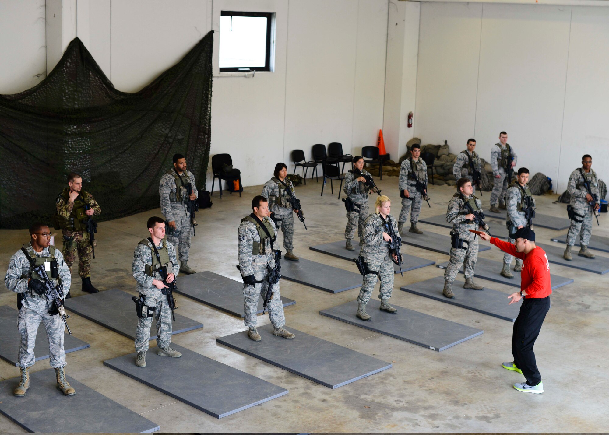 A civilian combat instructor shows 31st Security Forces Airmen proper sidearm drawing and holstering techniques during a week-long combat expertise training program, April 14, 2015, at Aviano Air Base, Italy. The training included weapons handling techniques, such as reloading, aiming and weapon switching. (U.S. Air Force photo by Senior Airman Austin Harvill/Released)