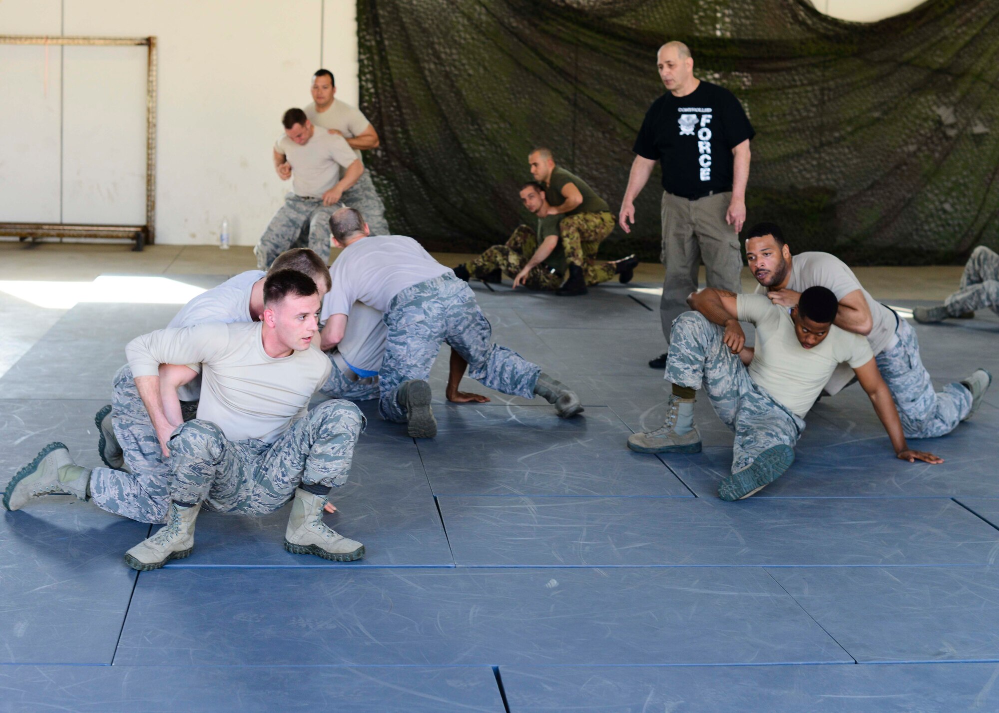 Airmen from the 31st Security Forces Squadron perform grappling techniques during a week-long combat expertise training program April 13, 2015, at Aviano Air Base, Italy. Airmen learned multiple ways to disengage from assailants with proper use of force. (U.S. Air Force photo by Senior Airman Austin Harvill/Released)