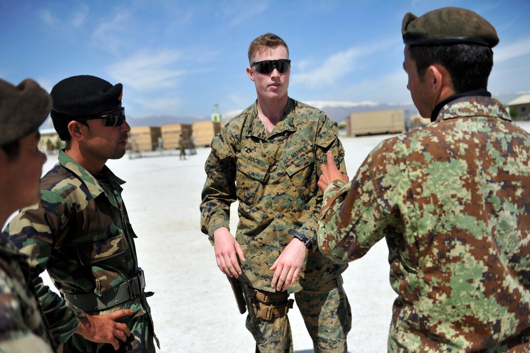 U.S. Marine Corps 1st Lt. Andrew Dixon, center, talks to Afghan military policemen and soldiers during infantry tactics and techniques training on Afghan Military Police Guard Compound in Parwan province, Afghanistan, April 5, 2015. Dixon is assigned to the Georgian Deployment Program.