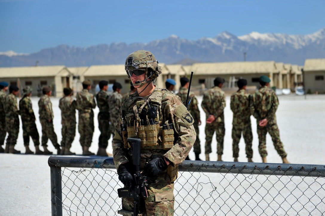 A U.S. soldier provides security while U.S. Marines train Afghan military policemen on infantry tactics and techniques at the Afghan Military Police Guard Compound in Parwan province, Afghanistan, April 5, 2015.