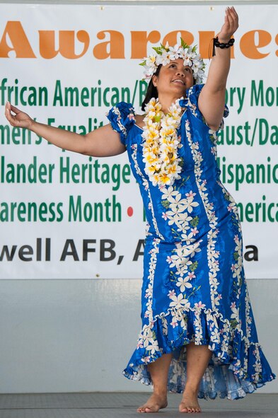 Master Sgt. Camella Apsay, 42nd Medical Support Squadron Tricare operations and patient administration flight chief, performs a traditional Asian American-Pacific Islander dance during Cultural Awareness Day, April 10, 2015, at Maxwell Air Force Base, Alabama. The Asian American-Pacific Islander heritage table served popular dishes native to the culture while surrounded by a display featuring plants and a tropical backdrop representing the Pacific islands. (U.S. Air Force photo by Melanie Rodgers Cox)