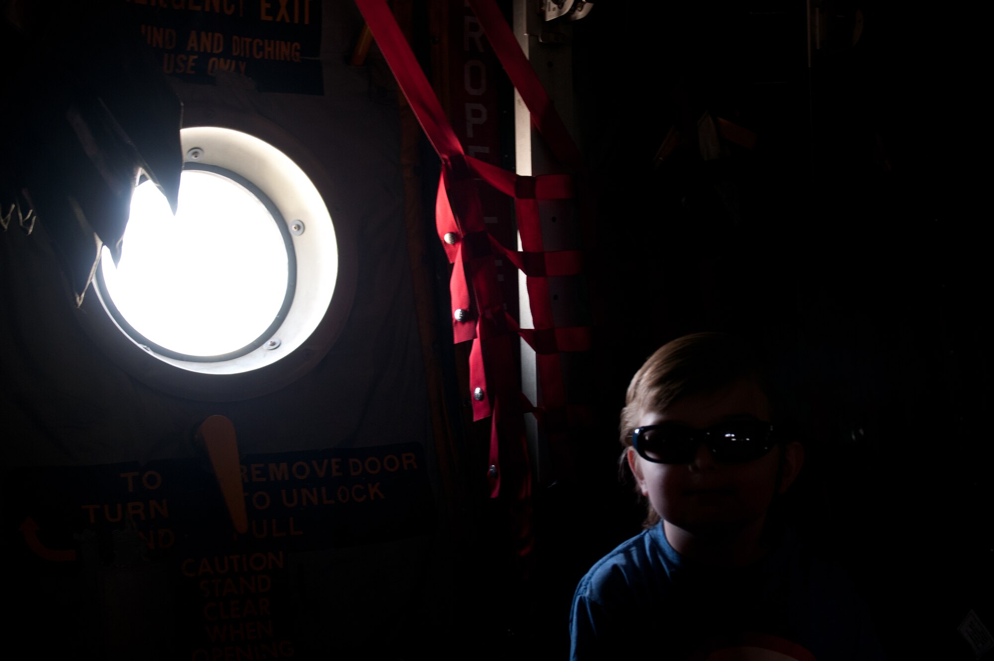 Nine-year-old Dawson Barr sits in a troop seat on a 123rd Airlift Wing C-130 Hercules aircraft during a tour of the Kentucky Air National Guard Base in Louisville, Ky., April 18, 2015.  Dawson has been battling cancer his entire life and currently has an inoperable brain tumor, making him legally blind in both eyes. (U.S. Air National Guard photo by 2nd Lt. James W. Killen)