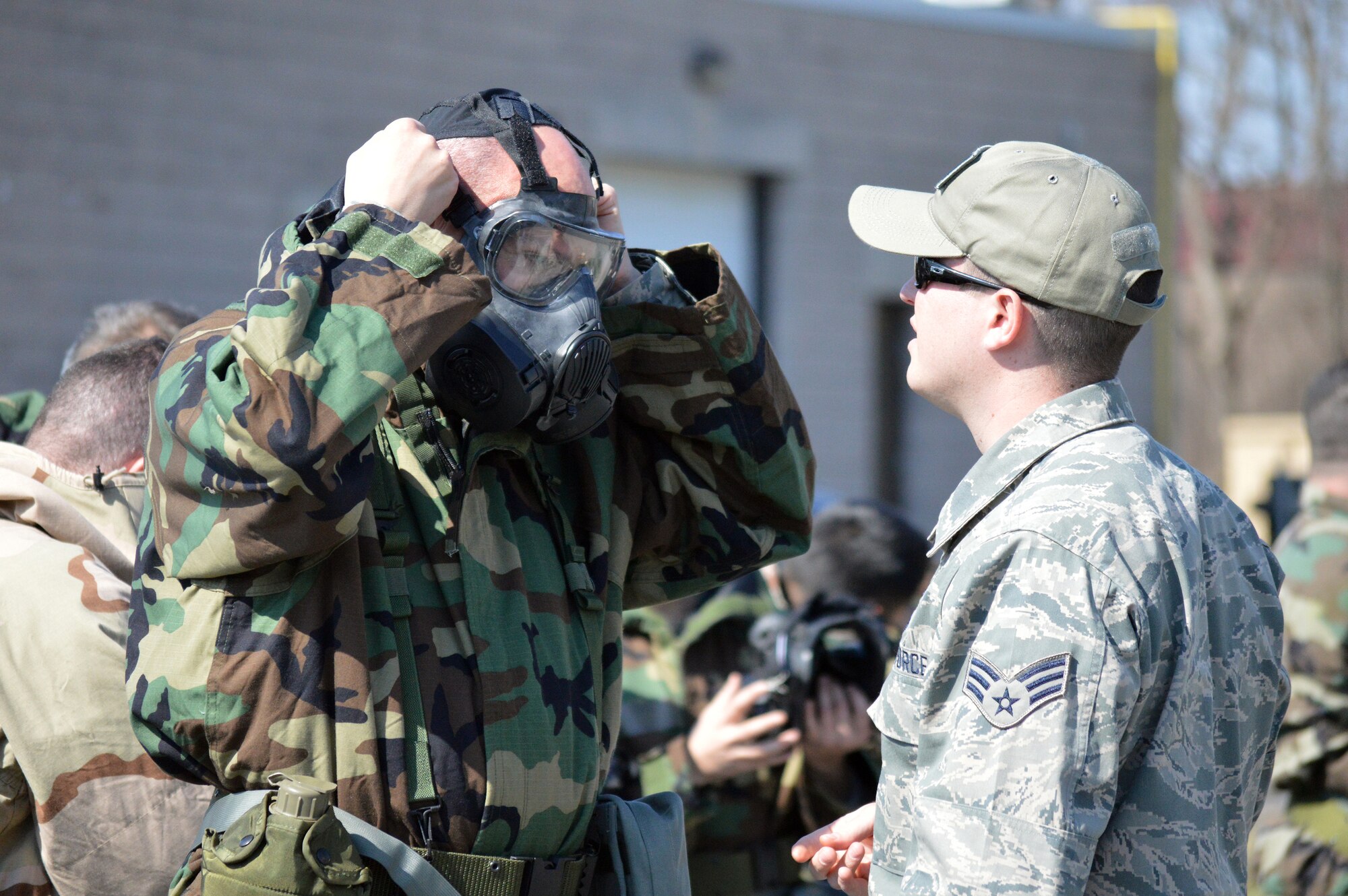 Senior Airman Patrick Irwin, 109th Civil Engineer Squadron's emergency management instructor, assists Lt. Col. Ronald Ankabrandt, 109th Airlift Wing inspector general, adjust his mask during the hands-on chemical, biological, radiological and nuclear training at Stratton Air National Guard Base, New York, on April 18, 2015. The training was part of the 109th AW's first ancillary training rodeo where more than 200 Airmen were trained on CBRN as well as self-aid and buddy care. (U.S. Air National Guard photo by Tech. Sgt. Catharine Schmidt/Released)