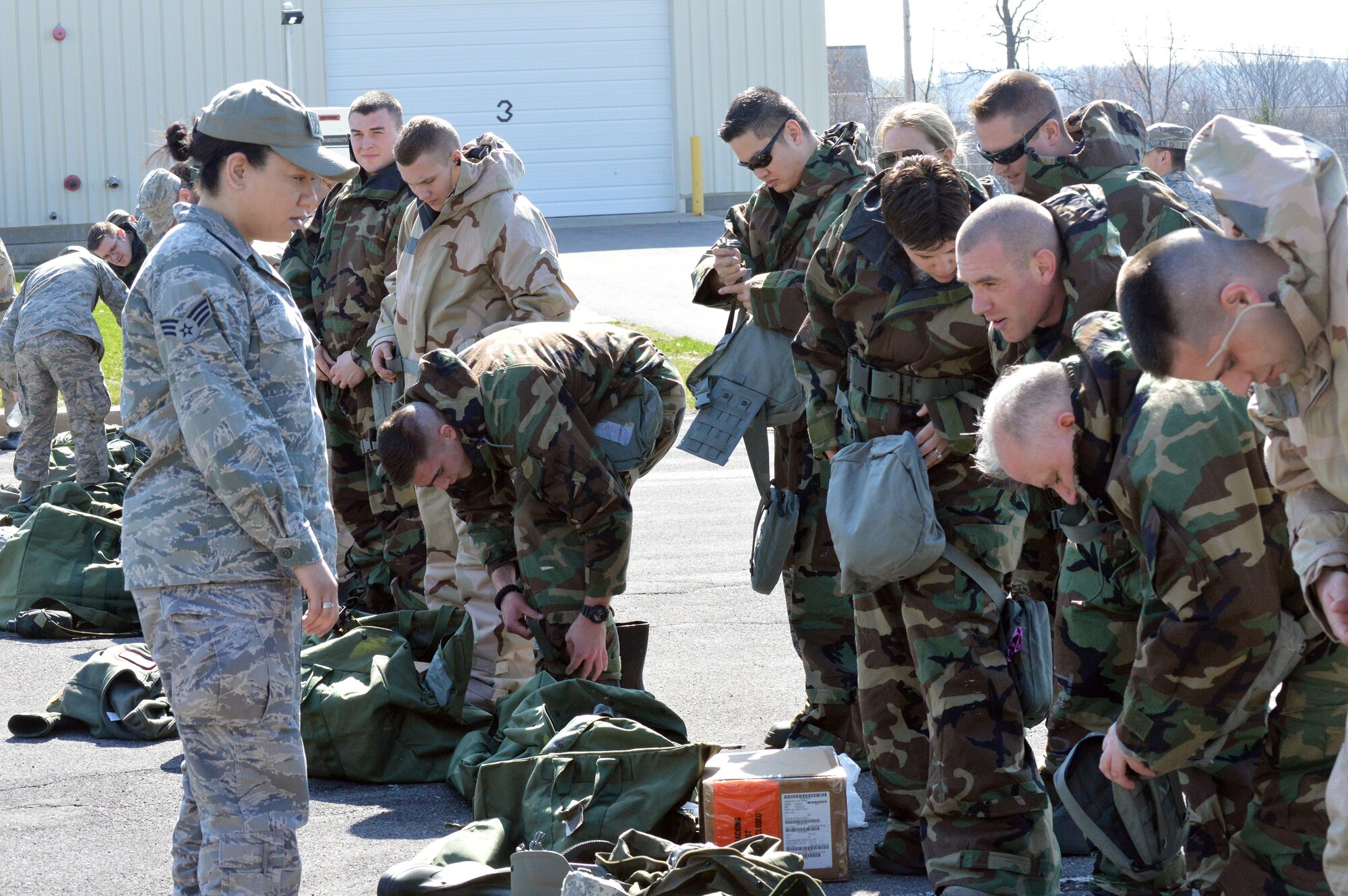 Senior Airman Siaianne Roberts, 109th Medical Group, observes Airmen don their mission-oriented proective posture gear during the hands-on chemical, biological, radiological and nuclear training at Stratton Air National Guard Base, New York, on April 18, 2015. The training was part of the 109th Airlift Wing's first ancillary training rodeo where more than 200 Airmen were trained on CBRN as well as self-aid and buddy care. (U.S. Air National Guard photo by Tech. Sgt. Catharine Schmidt/Released)