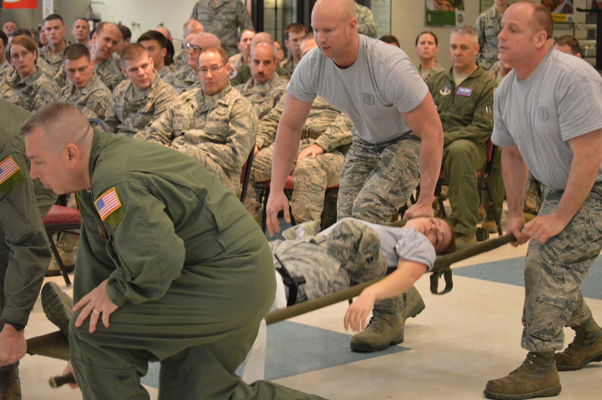 Volunteers demonstrate self-aid buddy care in a combat situation during a briefing as part of the 109th Airlift Wing's first ancillary training rodeo April 18, 2015. More than 200 Airmen went through the training which also included hands-on SABC as well as hands-on chemical, biological, radiological and nuclear training. (U.S. Air National Guard photo by Tech. Sgt. Catharine Schmidt/Released)