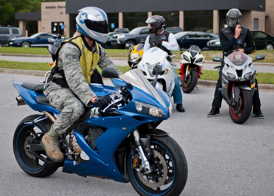 An Airman cruises by a group of riders. (U.S. Air Force photo/Samuel King Jr.) 

