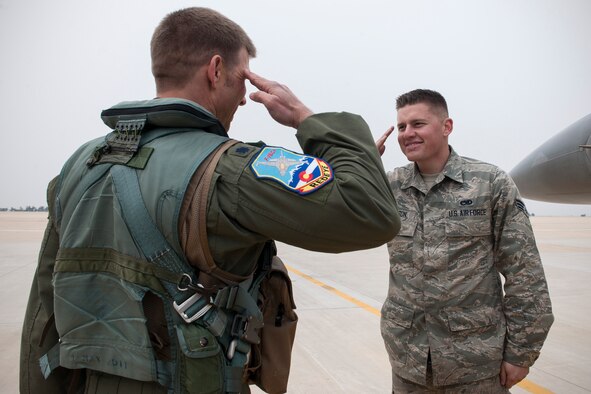 Senior Airman Mitchell Jamison, a 120th Expeditionary Aircraft Maintenance Unit crew chief, salutes his father, Lt. Col. James Reeman, 120th Expeditionary Fighter Squadron F-16 Fighting Falcon pilot, April 16, 2015, at Kunsan Air Base, South Korea. Reeman and Jamison, both from Colorado Air National Guard’s 140th Wing, are temporarily assigned to Kunsan as part of a rotational theater security package for approximately three months. (U.S. Air Force photo/Senior Airman Katrina Heikkinen)