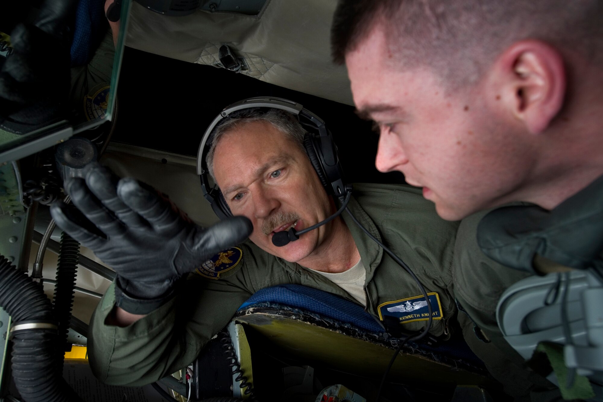 Master Sgt. Kenneth Knight, 72 Air Refueling Squadron in-flight refueling technician, explains aerial refueling to Eric Hickok, University of Notre Dame Air Force ROTC Detachment 225 cadet, during an orientation flight on a 434th Air Refueling Wing KC-135R Stratotanker that departed from Grissom Air Reserve Base, Ind., April 1, 2015. During the flight 20 cadets and 6 midshipmen boarded two KC-135Rs to observe the refueling of a C-17 Globemaster III and an A-10 Thunderbolt. (U.S. Air Force photo/Tech. Sgt. Benjamin Mota)
