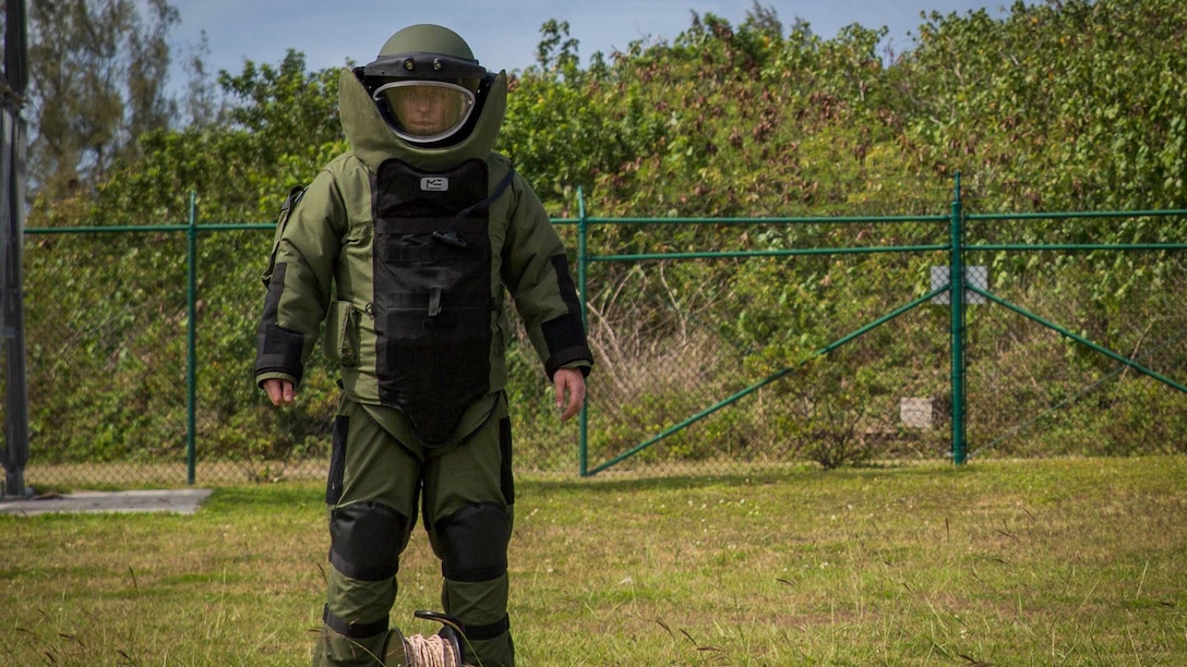 Staff Sgt. Steven M. Smith, a team leader with Explosive Ordnance Disposal Headquarters Battalion, wears a bomb suit and prepares to conduct mechanical entry of a car utilizing hook and line during a International Association of Bomb Technicians & Investigators conference aboard Marine Corps Base Hawaii, March 15, 2015. 