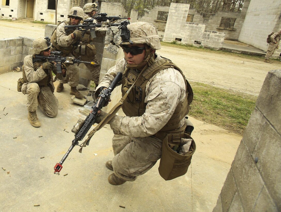 A Marine with Light Armored Reconnaissance, Battalion Landing Team 2/6, 26th Marine Expeditionary Unit, rounds a corner as his team exfils out of a building as part of a simulated raid aboard Fort Pickett, Va., April 16, 2015. Marines simulated a raid on a Military Operations in Urban Terrain (MOUT) training town as part of their Realistic Urban Training. During the training, Marines were tasked with clearing the objective building as well as detaining role-players and egressing out of the town. During this, the Marines reacted to simulated casualties and realistic changes of mission objectives. (Official U.S. Marine Corps photo by Lance Cpl. Dalton A. Precht)