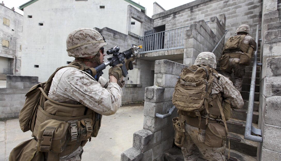 U.S. Marines with Fox Company, Battalion Landing Team 2/6, 26th Marine Expeditionary Force, prepare to enter a building during military operations in urban terrain (MOUT) at Fort Pickett, Va., April 11, 2015. The 26th MEU is conducting realistic urban training in preparation for deployment in the 5th and 6th Fleet areas of responsibility later this year. (U.S. Marine Corps Photo by Staff Sgt. Bobby J. Yarbrough/Released)