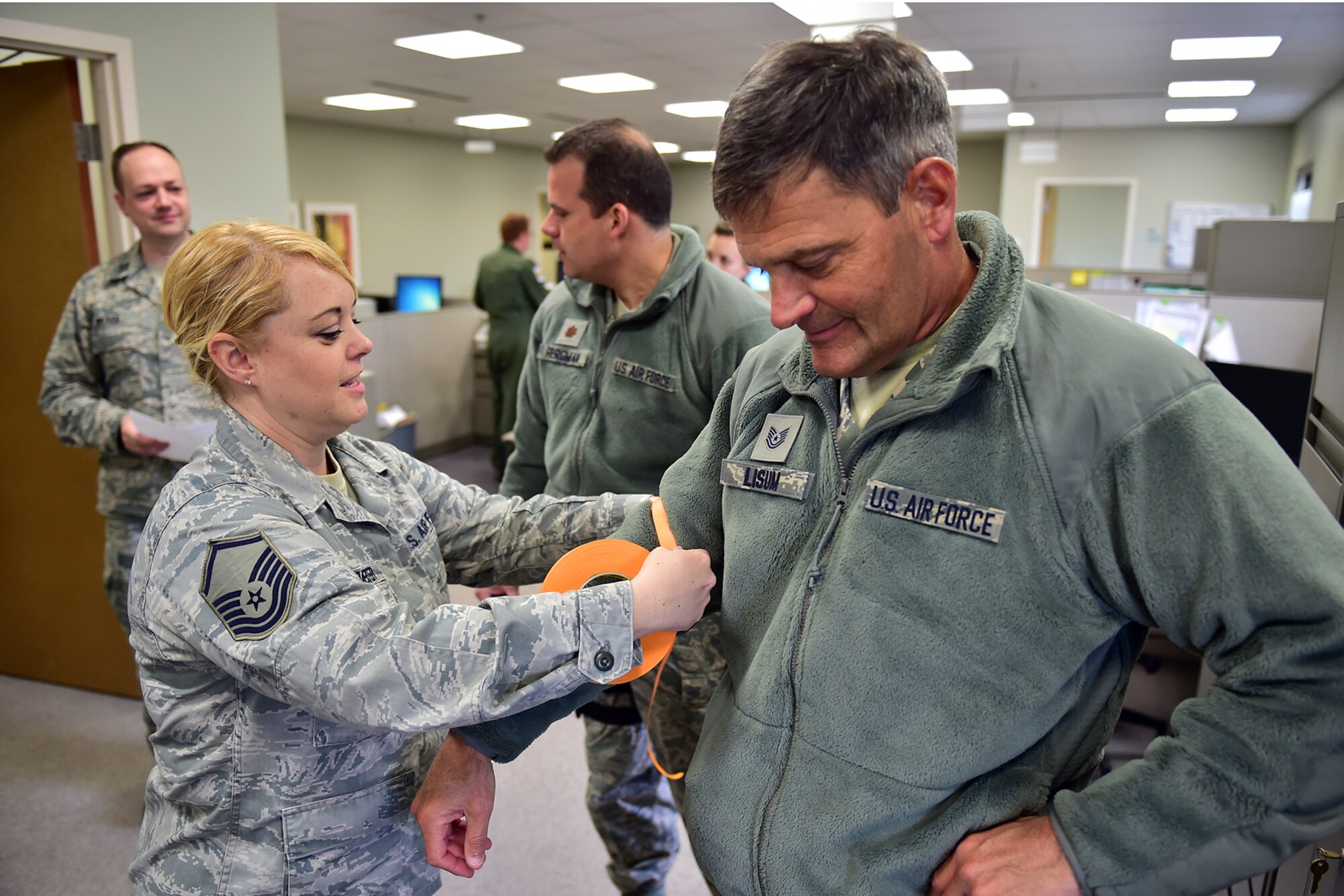 Air Force Reserve Master Sgt. Sarah Hofmeister places simulated M4 chemical agent detection tape on Tech. Sgt. Rick Lisum’s arm during the Operation Patriot Penguin mobilization exercise here, April 11, 2015. Hofmeister is the 910th Airlift Wing Staff Unit Deployment Manager (UDM) and Lisum is a photojournalist for the 910th Airlift Wing Public Affairs Office.  (U.S. Air Force photo/Tech. Sgt. James Brock)