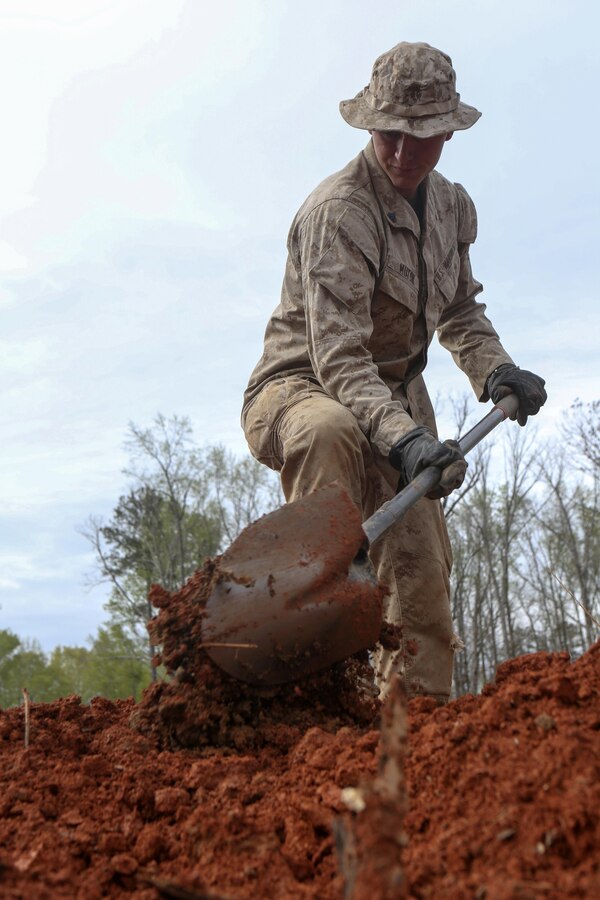 A U.S. Marine with Engineer Detachment, Combat Logistics Battalion 26, 26th Marine Expeditionary Unit, digs a defensive position during patrol base construction training at Fort Pickett, Va., April 15, 2015. The 26th MEU and its supporting elements are conducting realistic urban training in preparation for deployment to the 5th and 6th Fleet areas of responsibility later this year. (U.S. Marine Corps photo by Cpl. Joshua W. Brown/Released)