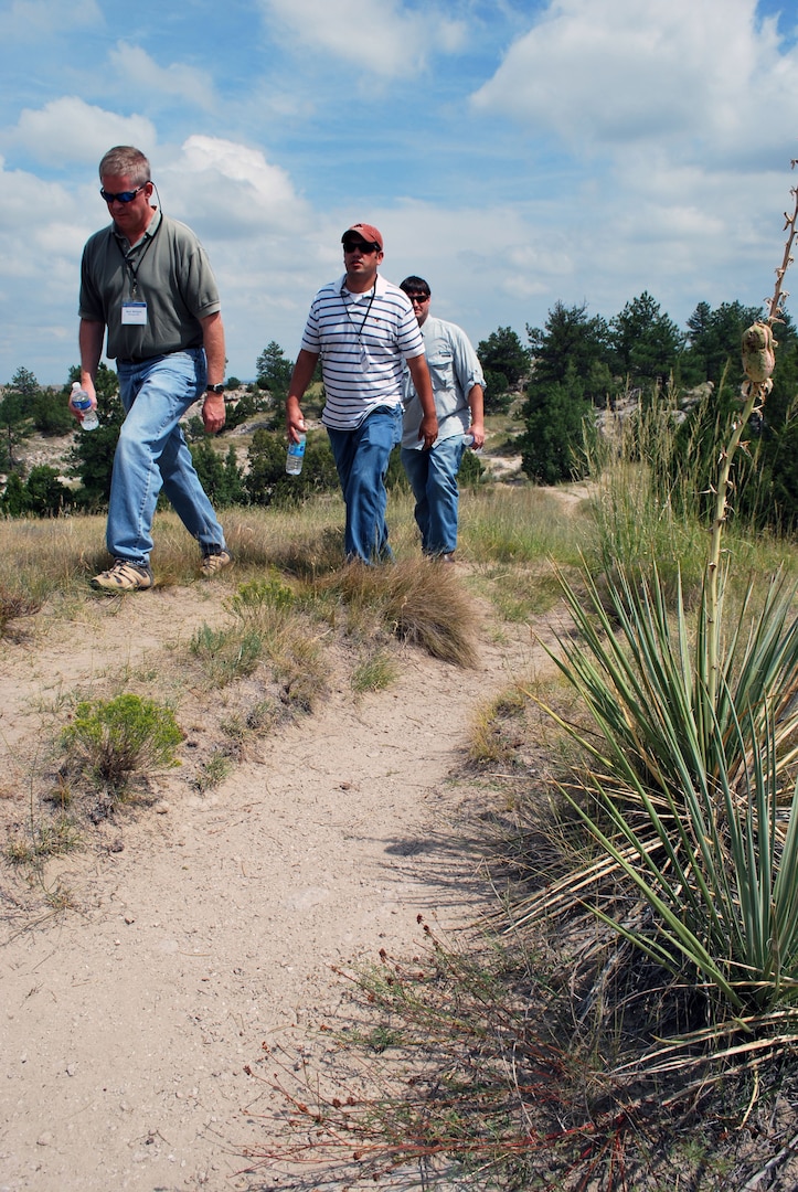 Mark Williams, left, of the Mississippi Army National Guard, Michael Peterkin, middle, of the Indiana Army National Guard, and Kenneth Keith, of the Mississippi Army National Guard, hike through the ruts in the Oregon
Trail historic site near Guernsey, Wyo., in August. The trio participated in the National Guard Bureau's Natural and Cultural Resources Workshop, hosted in Wyoming. The Wyoming Guard arranged for a tour of culturally important sites during the multi-day conference.