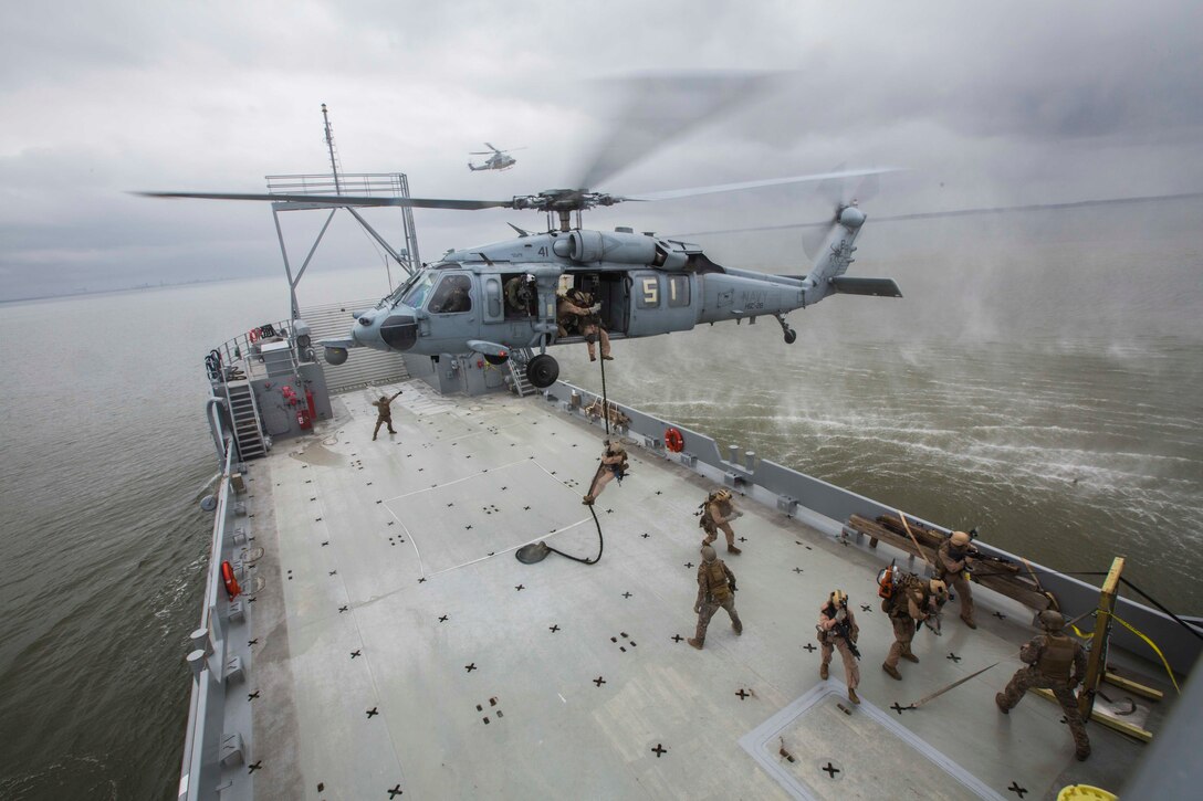 U.S. Marines assigned to Force Reconnaissance Platoon, Maritime Raid Force, 26th Marine Expeditionary Unit (MEU) fast-rope from a SH-60 Seahawk onto a ship during Visit, Board, Search, and Seizure (VBSS) training at Joint Base Langley-Eustis, Va., April 14, 2015. The Marines were evaluated on their training as part of preparation for deployment to the 5th and 6th Fleet Areas of responsibility later this year. (U.S. Marine Corps photo by Lance Cpl. Andre Dakis/26th MEU Combat Camera/Released)
