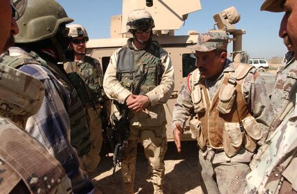 An Iraqi Army platoon sergeant from the 1st Battalion, 1st Brigade of the 4th Iraq Army Division briefs Lt. Chad Knowles, a Colts platoon leader from the Idaho National Guard's 1st Battalion, 148th Field Artillery, Task Force Liberty, before a joint counter-IED and combat patrol on Sept. 11, 2005.
