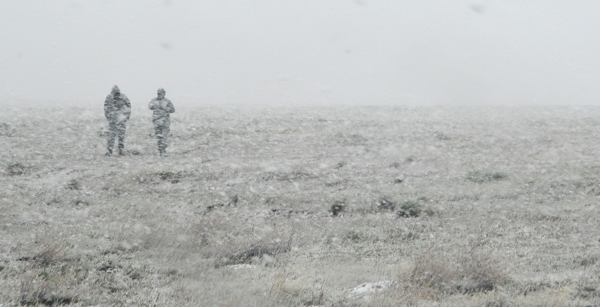 Airmen walk through a snowstorm during Gunfighter Flag 15-2 at Saylor Creek Range, Idaho, April 14, 2015. The unexpected whiteout conditions temporarily shut down the exercises scheduled that day. (U.S. Air Force photo/Senior Airman Lauren-Taylor Levin)