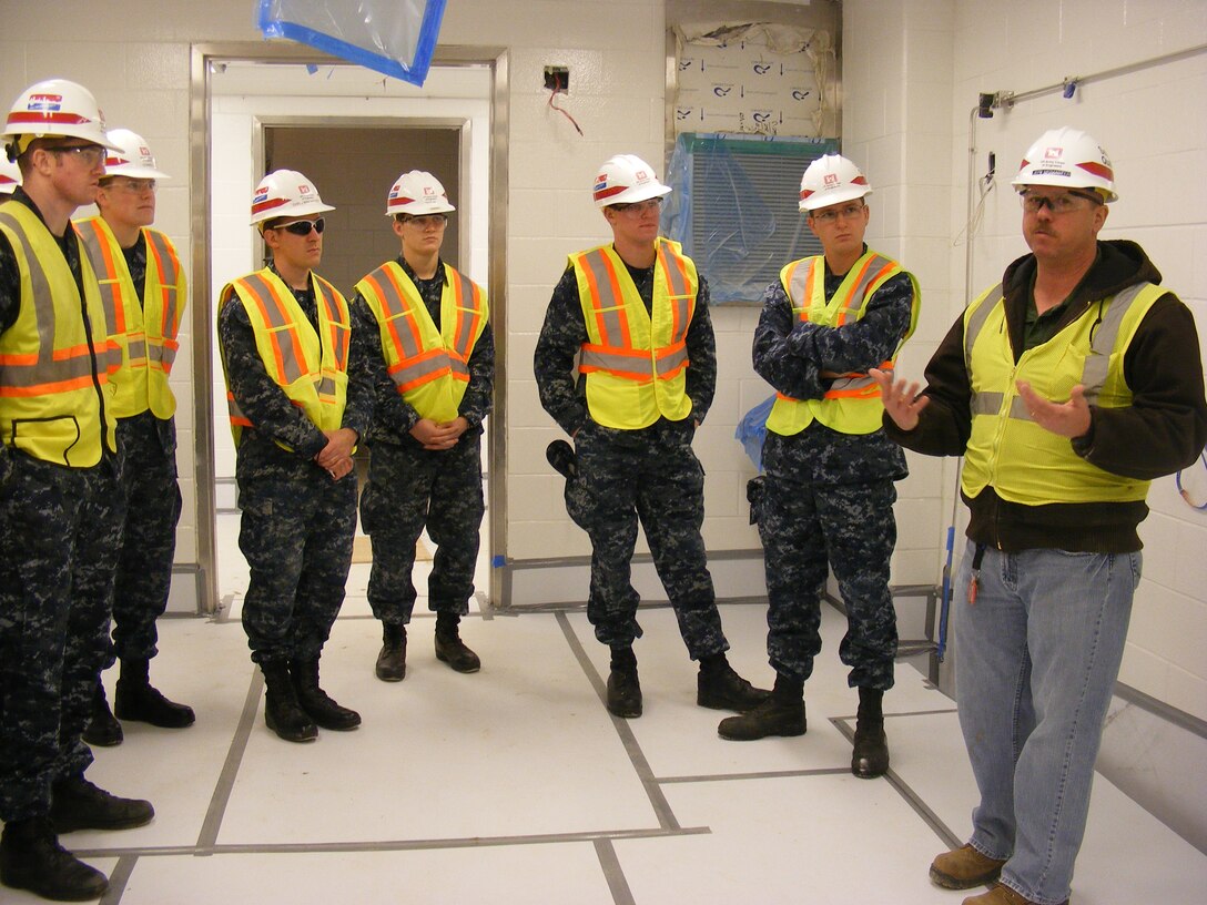 Jeff McMaster (right) briefs Midshipmen on the construction process at the USAMRIID project.