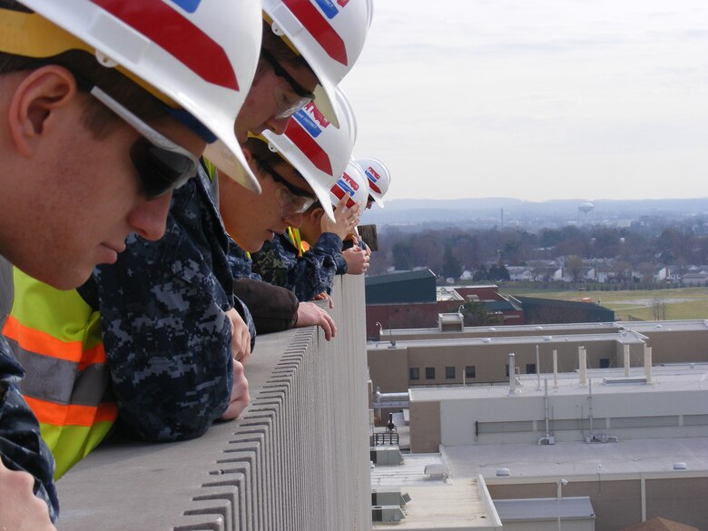 Midshipmen peer over the rooftop edge at the USAMRIID replacement project building to get a wider perspective of the National Interagency Biodefense Campus on Fort Detrick, Maryland.