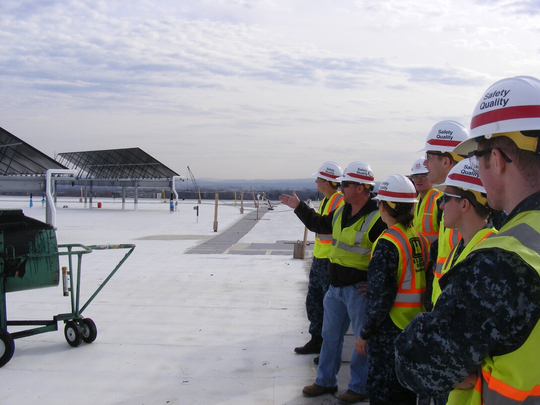 Jeff McMaster explains to Naval Academy midshipment why the solar panels and the white painted rooftop contribute to the LEED-Silver design for the USAMRIID replacement project.