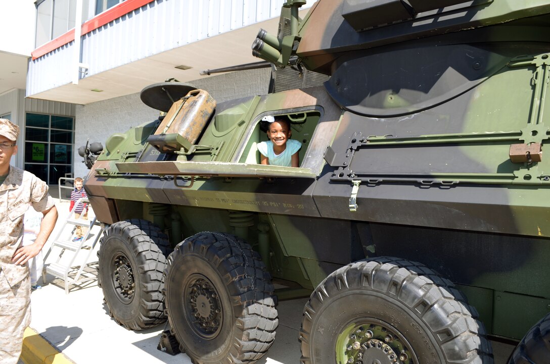 Saryi, 9, looks out of the side hatch of a light armored vehicle on Saturday. In honor of the Month of the Military Child, Marines from Delta Company, 4th Light Armored Reconnaissance Battalion, brought the LAV to the parking lot of the main exchange for children to explore.