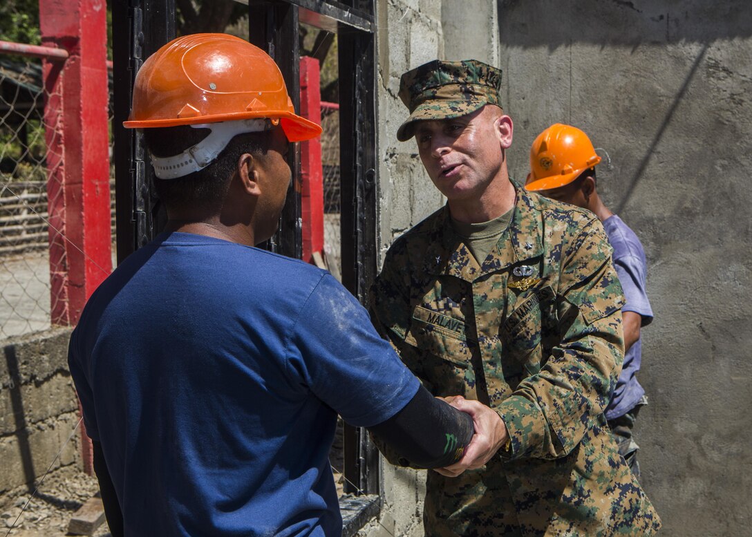 U.S. Marine Brig. Gen. Joaquin Malavet, right, I Marine Expeditionary Brigade commander, shakes the hand of Philippine Navy Petty Officer 3rd Class Alvin P Bautista, left, a Naval Combat Engineer Brigade engineer, at ENCAP Site 3, San Rafael Elementary School, Philippines, during exercise Balikatan 2015, April 17. Armed Forces of the Philippines Brig. Gen. Guillermo Molina  and Malavet visited the sites to meet the engineers who have been working shoulder to shoulder as well as get a firsthand look at the classrooms being built.