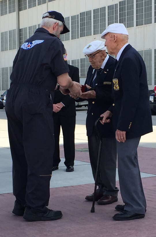Brian Anderson, Doolittle Tokyo Raiders Association sergeant of arms, hands the Congressional Gold Medal to Doolittle Raiders retired Lt. Col. Dick Cole and former Staff Sgt. David Thatcher after a ceremonial flight on board the B-25 “Panchito” at Wright-Patterson Air Force Base, Ohio, April 18, 2015. The medal is on display in the museum’s World War II Gallery in the Doolittle Raid exhibit.  (U.S. Air Force courtesy photo)