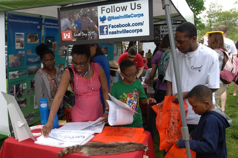 A family checks out the U.S. Army Corps of Engineers Nashville District booth April 18, 2015 during the Nashville Earth Day Festival at Centennial Park. They also collected water safety items and maps of local lakes that were available for free.