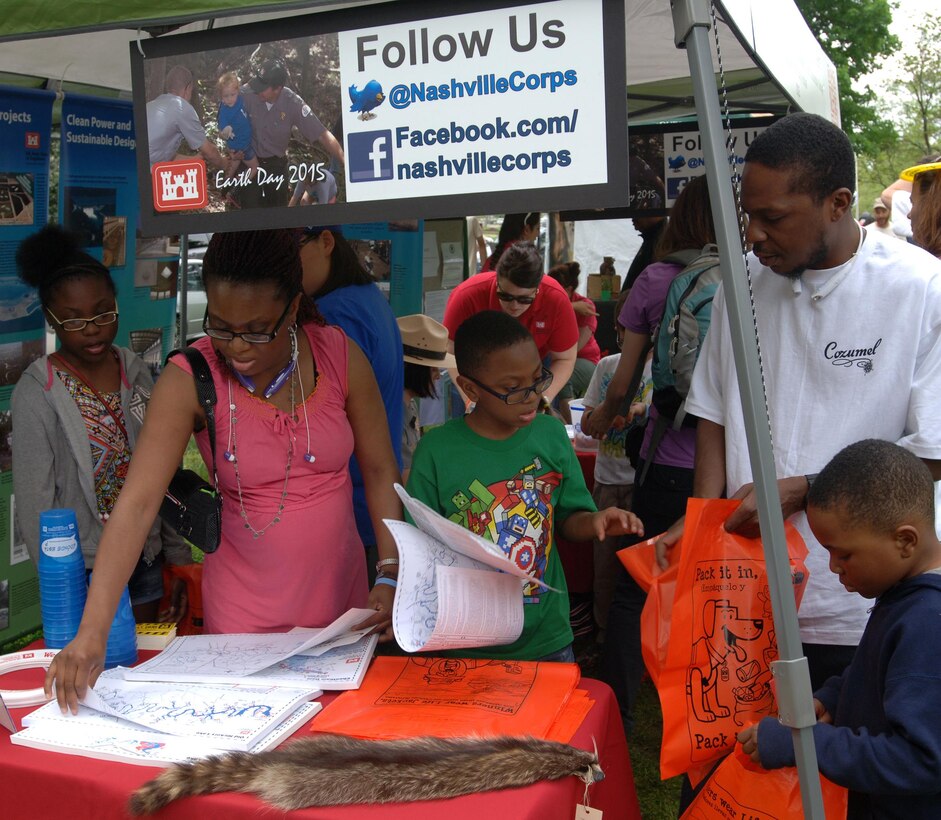A family checks out the U.S. Army Corps of Engineers Nashville District booth April 18, 2015 during the Nashville Earth Day Festival at Centennial Park. They also collected water safety items and maps of local lakes that were available for free. 