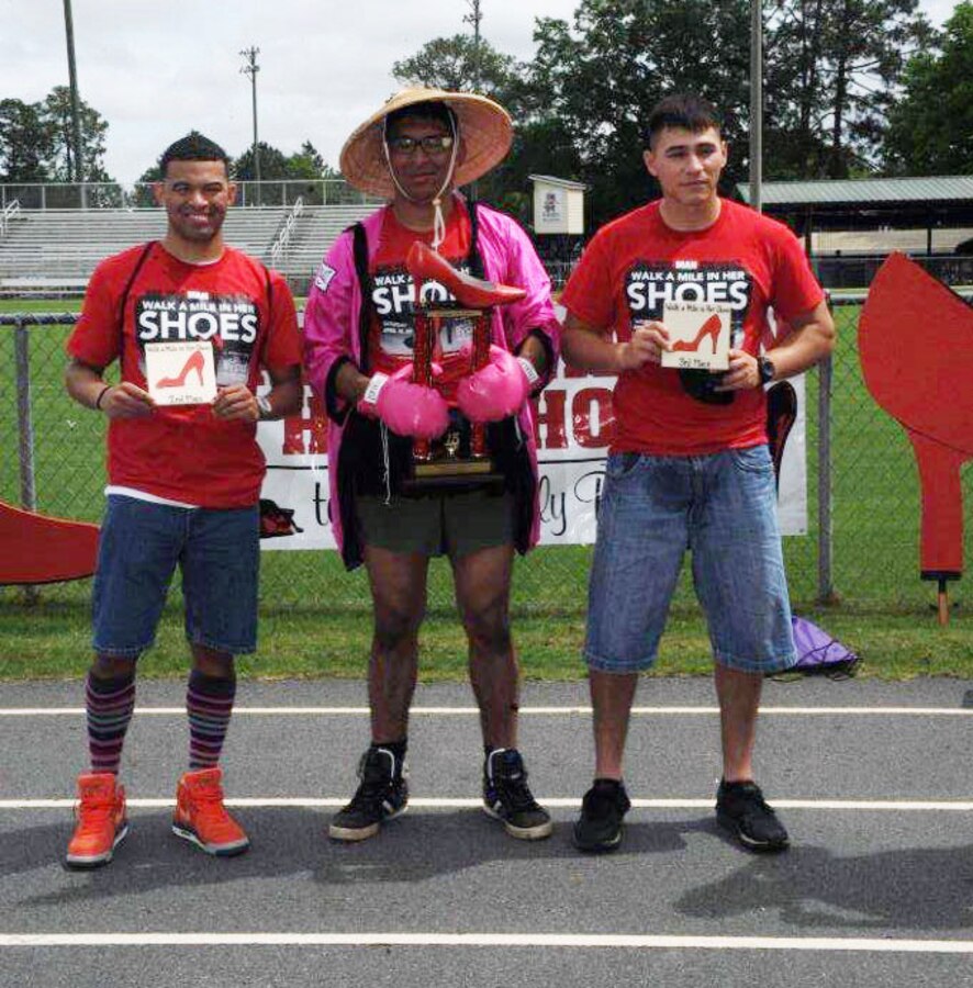 First place winner, Cpl. Jose Colindres (center), second place winner HM2 Ricky Cuevas (left) and third place winner Sgt. Marcos Noyola show off their trophies. Men from all walks of life, including Marines and Sailors stationed at Marine Corps Logistics Base Albany, volunteered to support the “Walk a Mile in Her Shoes” event benefitting Lily Pad, a local non-profit organization that supports victims of sexual assault and child abuse. The event was held April 18 at Deerfield-Windsor Upper Campus Track, Albany, Georgia.

