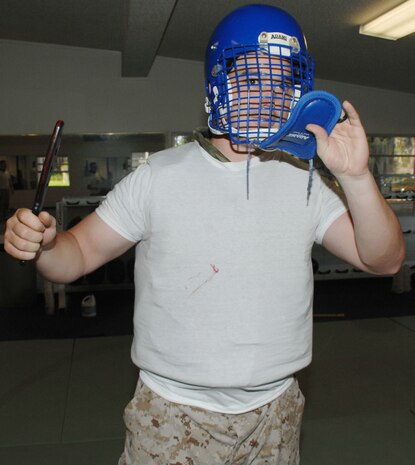 Marine Corps Martial Arts Program student Sgt. Nathan Phelps displays a smeared, fake blood stain on his white T-shirt he received from Cpl. Ariana Atterberry during a knife fighting techniques class at Marine Corps Logistics Base Albany’s dojo, recently.