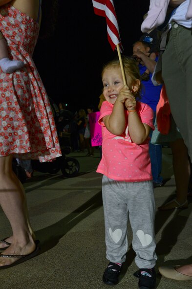 A child smiles at the sight of seeing the plane her father is arriving home from a deployment on at Shaw Air Force Base, S.C., March 18, 2015. Approximately 200 Airmen deployed to the United States Central Command AOR for six month and have returned home safely. (U.S. Air Force photo by Senior Airman Tabatha Zarrella/Released)